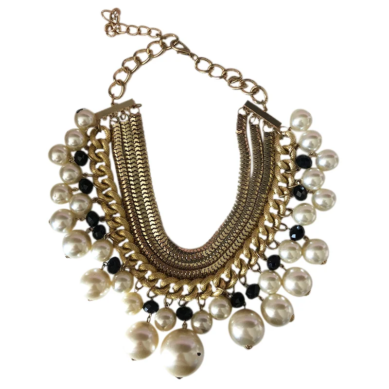 The RockStar Chains And Pearl Necklace features a gold layered chain adorned with large white pearls, small black beads, and an adjustable clasp.
